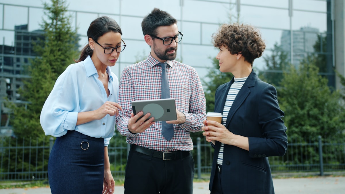 Equipo de trabajo sonriente revisando información en una tablet